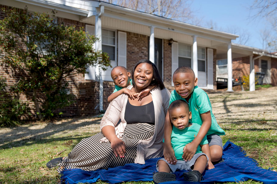 family of four outside house
